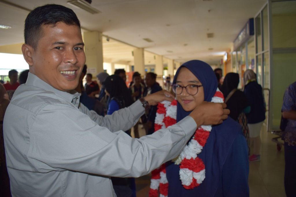 Plt. Kepsek MTsN 1 Model Banda Aceh Armaidi, S.Pd., M.Pd mengalungkan Bunga ke Aviva Khalila salah peserta KSM