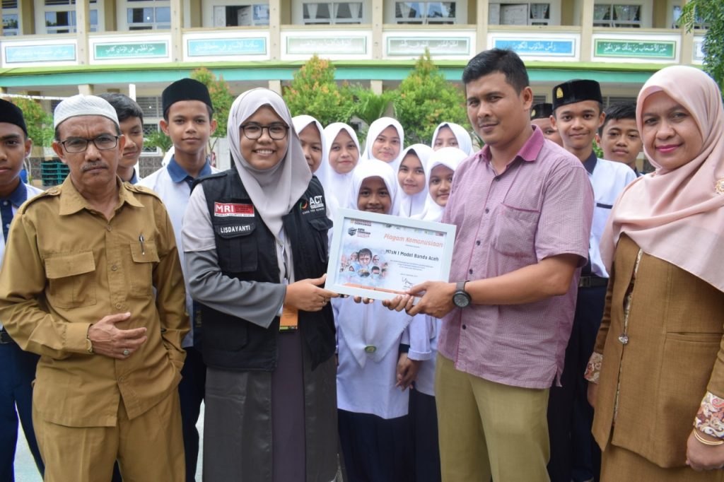 Wakil Kepala bidang kesiswaan MTsN 1 Model Banda Aceh didampingi Tursina dan Drs Abdullah Sani Koordinator Sosial dan keagamaan menerima piagam kemanusiaan yang diserahkan oleh Lisdayanti, Partnership Supervisor ACT wilayah Aceh, Senin (30/09/2019)