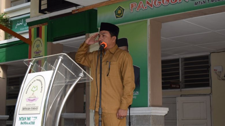 PENGHORMATAN: Kasi SarPras Pendidikan Madrasah (Penmad) Kanwil Kemenag Aceh, Syafruddin, S.Ag saat memberikan penghormatan pemimpin upacara. Senin,(14/10/2019)